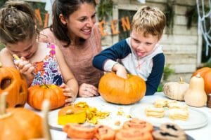mom and children carving pumpkins