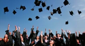 Highschool graduates tossing their caps in the air