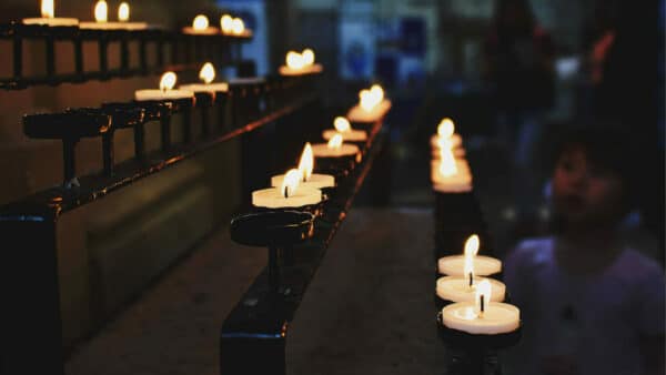 burning candles in church and people praying