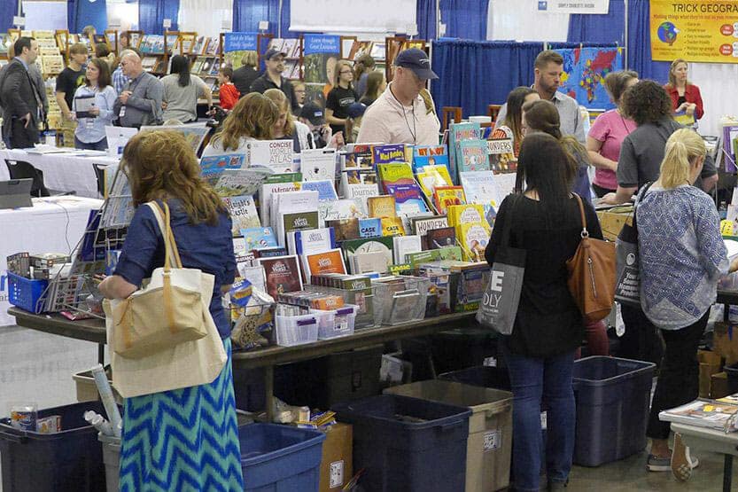 Homeschool parents browsing the resource fair at the Teach Them Diligently convention